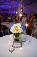 yellow roses, white lisianthus, blue hydrangea, and hanging amaranthus with manzanita branches and hanging votives