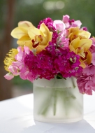 pink hydrangea and fuchsia stock featuring yellow cymbidium orchids in frosted glass